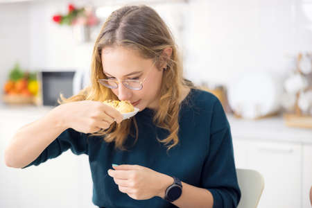 Making cakes and cookies is a lot of fun. In her kitchen, a young woman holds delicious fresh bread.
