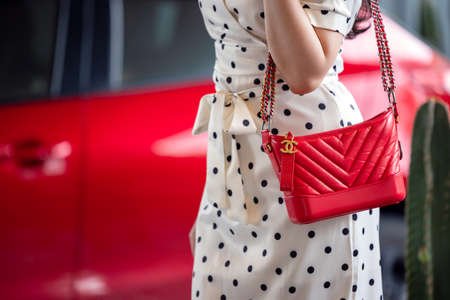 July 26, 2021: Nakhon Prathom, THAILAND, A woman holding a red Chanel square bag is a high-end fashion house that specializes in leather goods.のeditorial素材