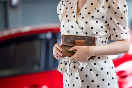 July 26, 2021: Nakhon Prathom, THAILAND, A woman carrying a Louis Vuitton square bag. Louis Vuitton is a high-end fashion house known for its leather goods.のeditorial素材