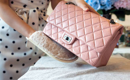 July 26, 2021: Nakhon Prathom, THAILAND, On the table, a woman cleans a pink Chanel handbag.