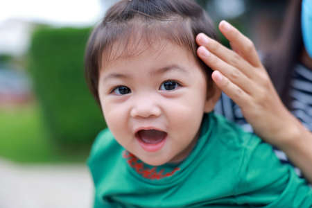 Portrait of a sweet tiny baby girl and her mother. Smile of a lovely young lady. a contented familyの写真素材