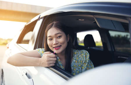 Makeup in the car, young woman applying makeup while drivingの写真素材