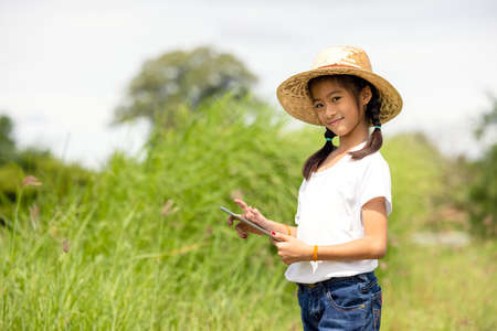 Outdoor Portrait Of A Little Girl Farmer On Rice Fieldsの写真素材
