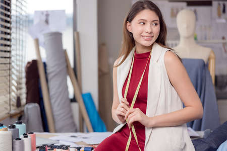 At work, a portrait of a smiling fashion designer and a creative woman is taken.の写真素材