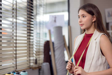 At work, a portrait of a smiling fashion designer and a creative woman is taken.の写真素材