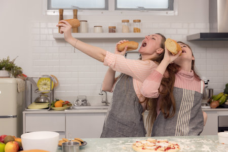 Mother and daughters use bread to sing and entertain one other.の写真素材