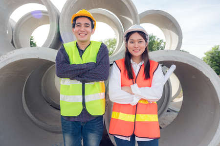 In the background, skyscraper concrete formwork frames, and a portrait of a confident female construction worker at a construction site.の写真素材