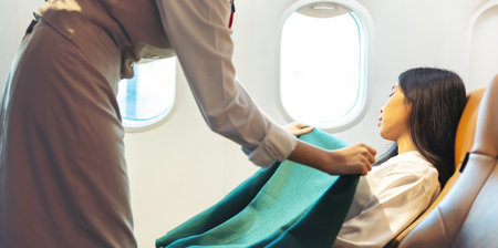 Happy stewardess looking after an adult businesswoman passenger, Air hostess or flight attendant...