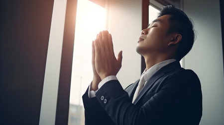 Using Generative AI, a businessman raises his hand in prayer.の素材