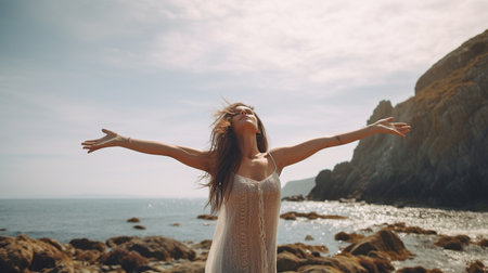Generative AI: a young, beautiful lady on a rocky beach, her arms wide, enjoying the breeze and taking in the fresh air.の素材