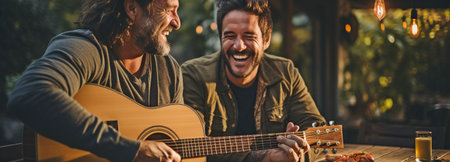Dad and grown-up son enjoying a game of guitar outside while toasting beer cups.の素材