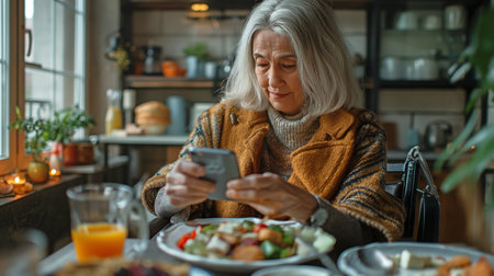 disabled adult woman using a smartphone to scroll while eating breakfast at home while seated at a tableの素材