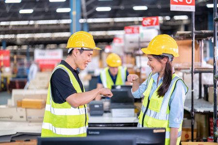 Staff working in large depot storage warehouse trainee check packing box congrats with trainerの写真素材