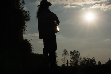 Handsome young man playing the acoustic guitar very happy. The straw on the farm Warm sunshine.の写真素材