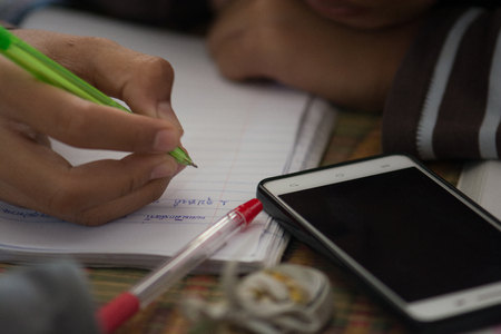 Male students are doing homework with intent. Search the Internet and in phone books. To prepare teachers.の写真素材