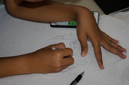 Children's drawing on a white shirt with a black pencil. Beautiful craftsmanship.の写真素材
