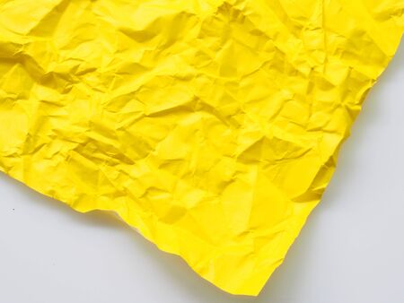 TheYellow crumpled paper on white background