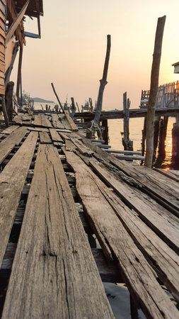 Old wooden bridge at the fisheries village in the sunsetの写真素材
