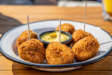 Dutch bitterbal on a plate; traditional pub snack appetizer with mustardの写真素材