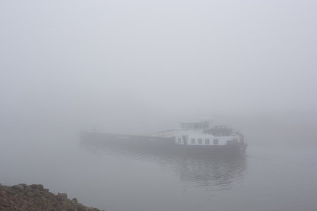 Sailing ship in fog on the river IJssel in the city of Deventer in the Netherlandsの写真素材
