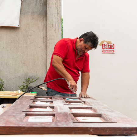 Man fixing a wood door by himself in his house patioの写真素材