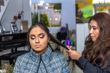 woman dressed in black blouse putting makeup on another younger woman in a white roomの写真素材