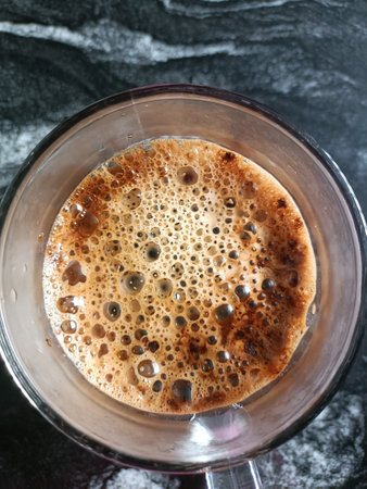 Coffee in a glass on a dark background, top view