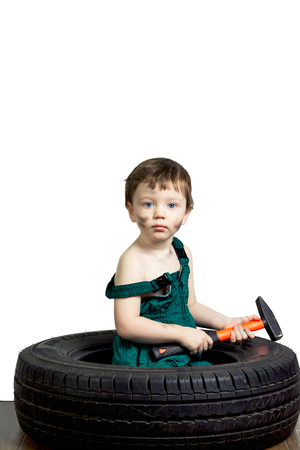 Little boy in a green suit with the tools and the wheelの写真素材
