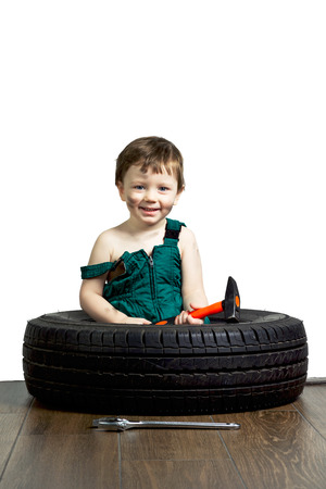 Little boy in a green suit with the tools and the wheelの写真素材