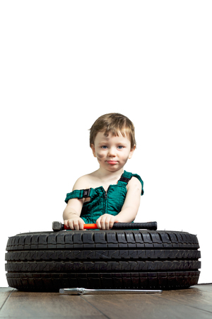 Little boy in a green suit with the tools and the wheelの写真素材