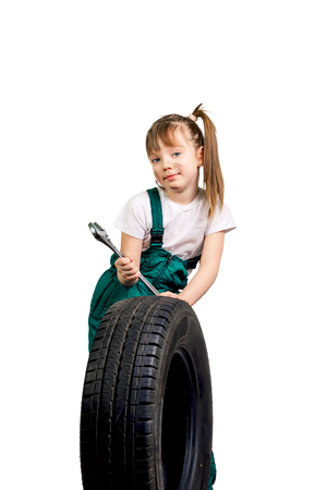 young girl mechanic in green clothes with a wheel and hammerの写真素材