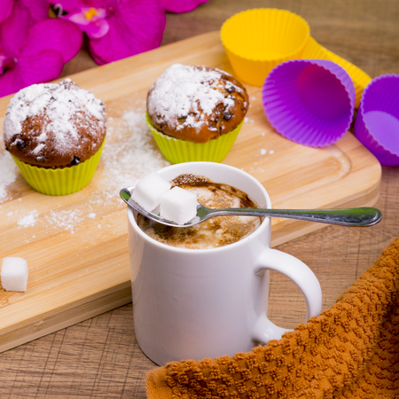 Bright Cupcake with icing sugar and chocolate on a colored background.の写真素材