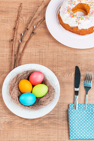Festive table with colorful Easter eggs and  cupcakeの写真素材