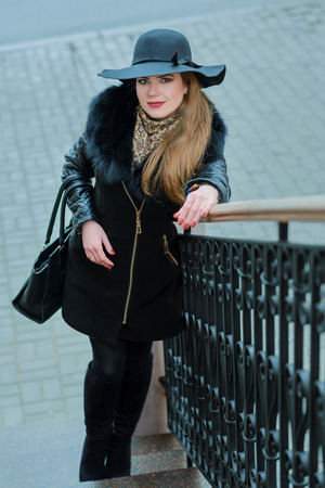 Beautiful girl with a smile in the hat walks around the city. Portraitの写真素材