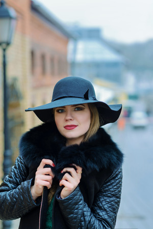 Beautiful girl with a smile in the hat walks around the city. Portraitの写真素材