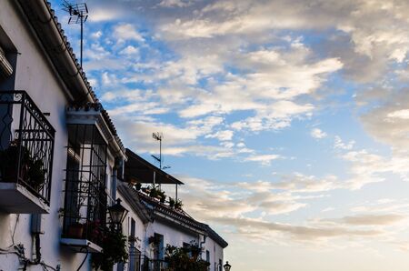 Typical white facade of the houses of the town of Mijas, Malaga, decorated with potted flowers