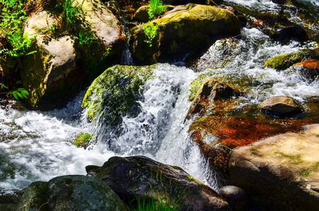 Stream of river water with a silky effect on the rocks. Small waterfallsの写真素材