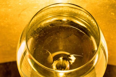 Wine glass with strong yellow light backgroundの写真素材