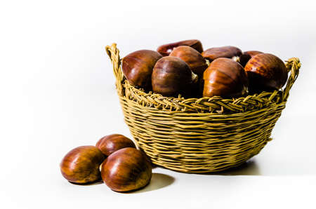 Chestnuts in wicker basket on white backgroundの写真素材