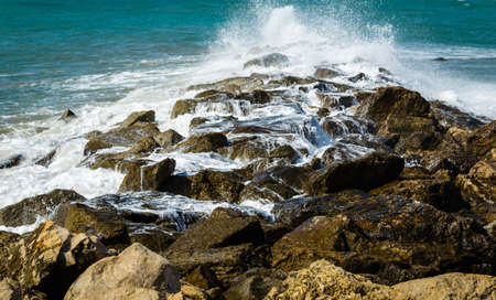 Close-up of sea waves breaking on the rocks of Vilanova y la Geltru beach