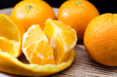 Oranges on wooden bowl with black backgroundの写真素材