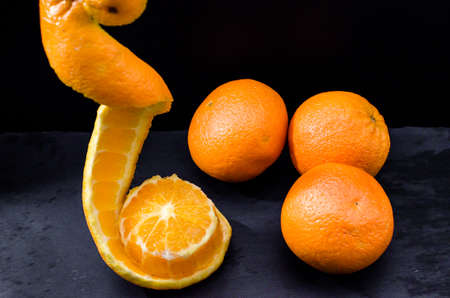 Oranges on wooden bowl with black backgroundの写真素材