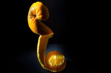 Orange on wooden bowl with black backgroundの写真素材
