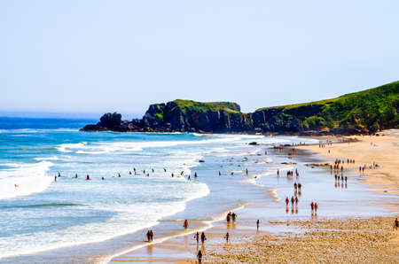 Beautiful view of people walking along a beach in Asturias in summer. Spainの写真素材