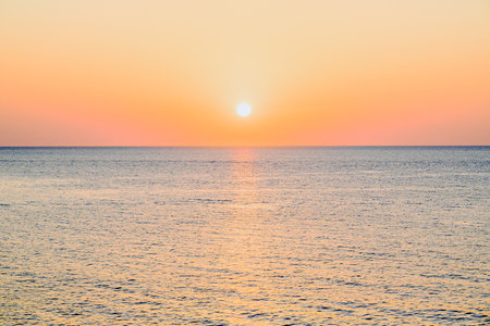 Beautiful sunset with orange sky on the beach of Menorca, Balearic Islands.の写真素材
