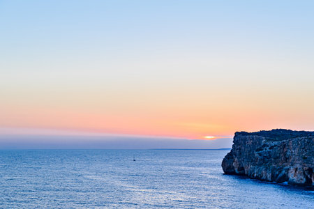 Beautiful sunset with orange sky on the beach of Menorca, Balearic Islands.の写真素材