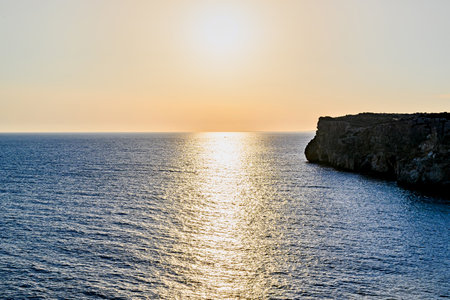 Beautiful sunset with orange sky on the beach of Menorca, Balearic Islands.の写真素材