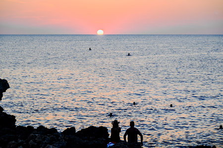 Beautiful sunset with orange sky on the beach of Menorca, Balearic Islands.の写真素材