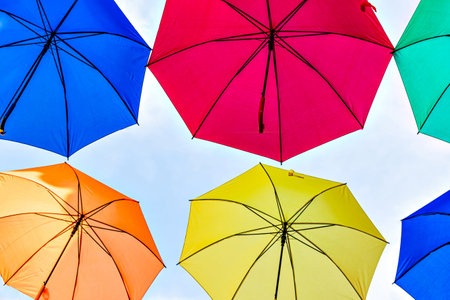 Background of many hanging colorful umbrellas decorating the street of a townの写真素材
