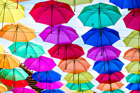 Background of many hanging colorful umbrellas decorating the street of a townの写真素材